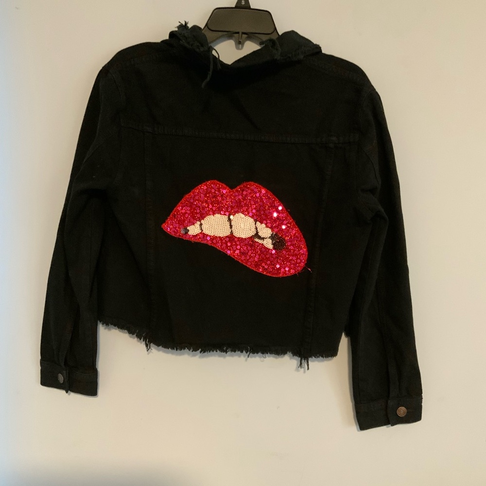Woman’s black cropped jacket with mouth/lips on back